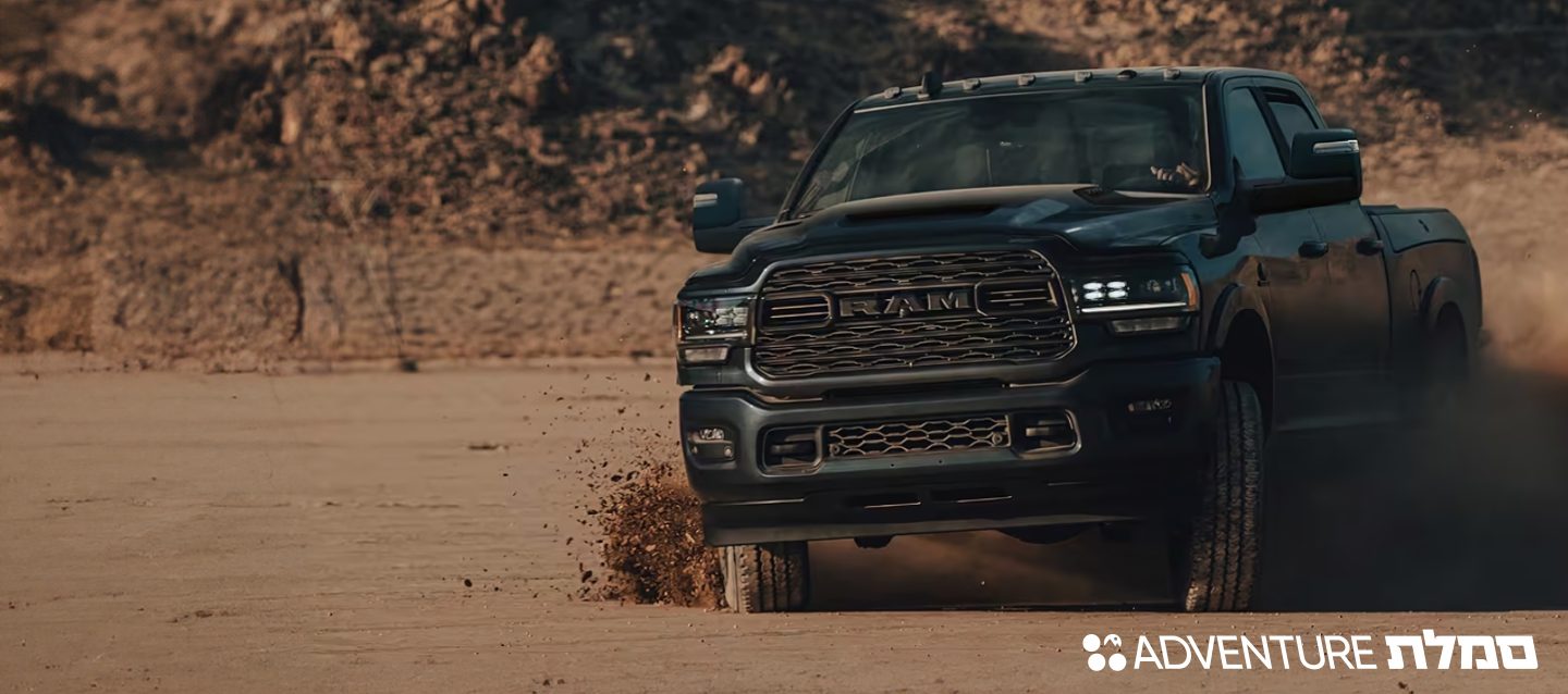 The front end of a Ram 1500 Rev with its headlamps on.