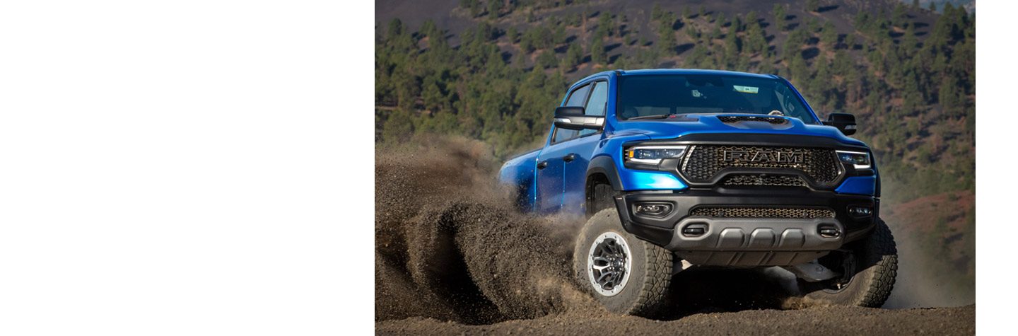 The 2023 Ram 1500 TRX being driven off-road on a dirt trail.