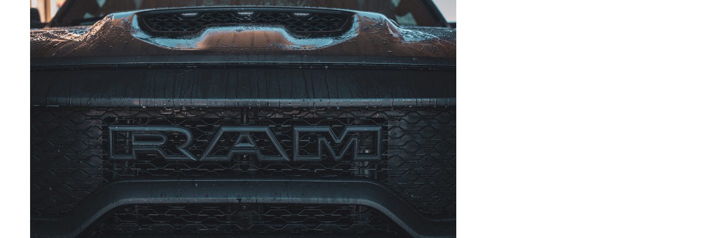 A close-up of the grille and hood scoop of the 2023 Ram 1500 TRX with water streaming off it.