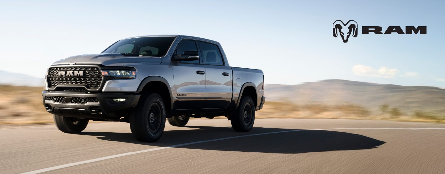 A black 2023 Ram 1500 Laramie 4x4 Crew Cab parked on a clearing in the desert at dusk. It's Ram season.