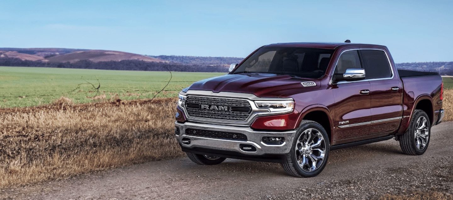 A black 2023 Ram 1500 Laramie 4x4 Crew Cab parked on a clearing in the desert at dusk. It's Ram season.